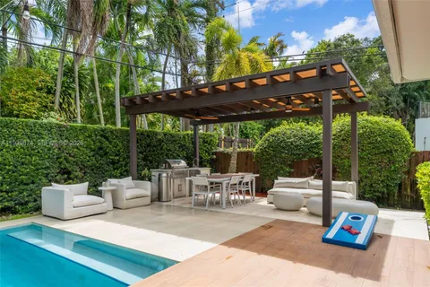 a view of a patio with table and chairs potted plants with wooden floor and fence
