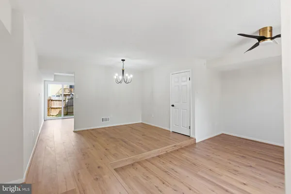 a view of a room with wooden floor and a ceiling fan