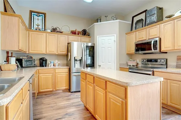 a kitchen with stainless steel appliances granite countertop a refrigerator stove microwave and sink