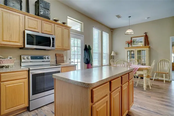 a kitchen with stainless steel appliances granite countertop a sink a stove top oven a counter space and cabinets