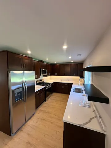 a large kitchen with stainless steel appliances a large counter top