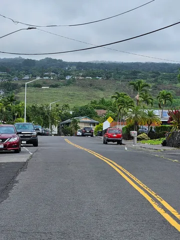 a view of a city street with parked cars