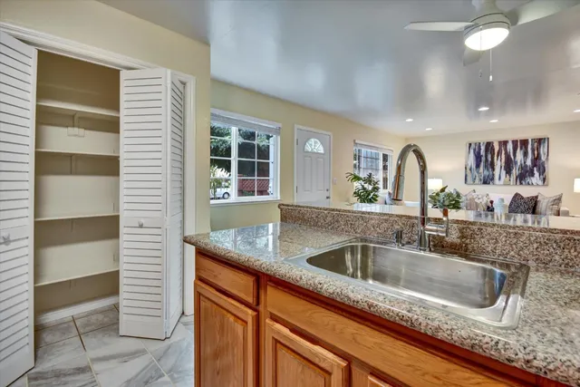 a kitchen with granite countertop a sink and a large mirror
