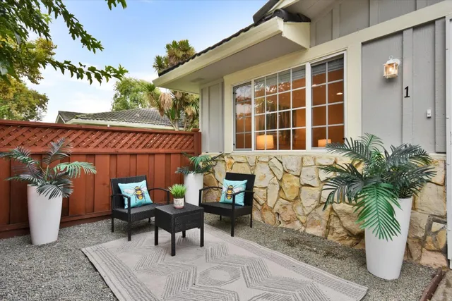 a view of a patio with couple of chairs and potted plants