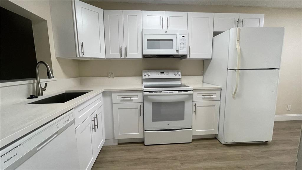 1439 Northwest 94th Way, Unit 1439 Coral Springs, FL 33071 - Photo 1 of 14 a kitchen with cabinets appliances and a sink