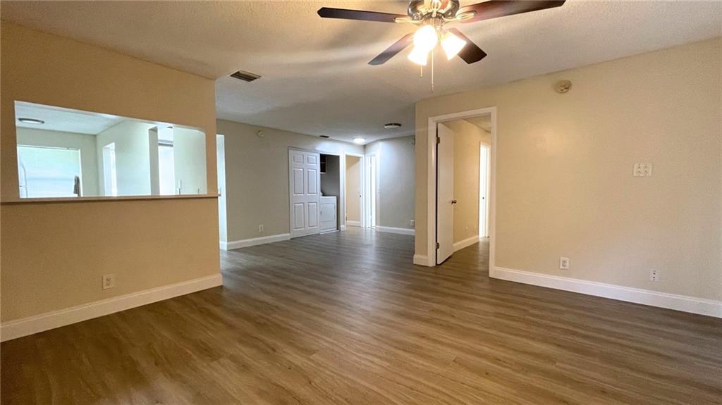 1439 Northwest 94th Way, Unit 1439 Coral Springs, FL 33071 - Photo 3 of 14 a view of an empty room with wooden floor and a ceiling fan