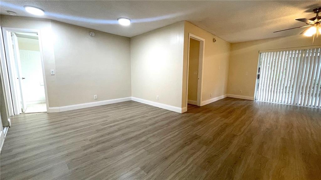 1439 Northwest 94th Way, Unit 1439 Coral Springs, FL 33071 - Photo 6 of 14 an empty room with wooden floor and windows
