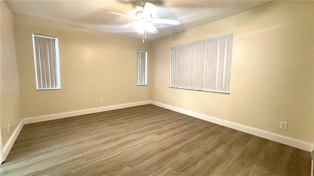 1439 Northwest 94th Way, Unit 1439 Coral Springs, FL 33071 - Photo 7 of 14 a view of an empty room with wooden floor and a window