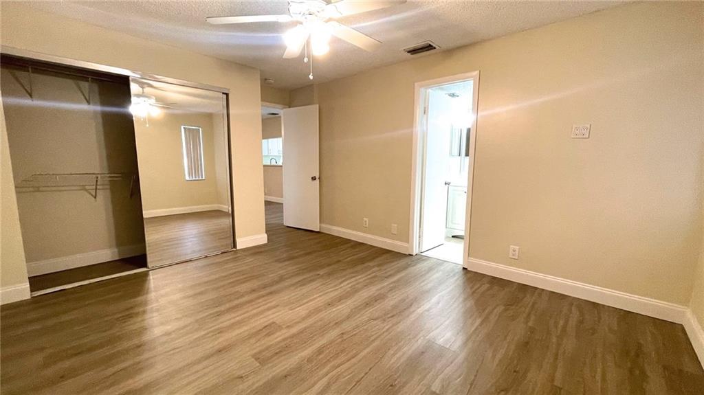 1439 Northwest 94th Way, Unit 1439 Coral Springs, FL 33071 - Photo 8 of 14 an empty room with wooden floor and a ceiling fan
