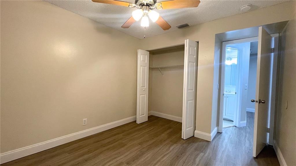 1439 Northwest 94th Way, Unit 1439 Coral Springs, FL 33071 - Photo 9 of 14 an empty room with wooden floor and a ceiling fan