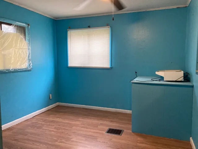an empty room with a window and a ceiling fan