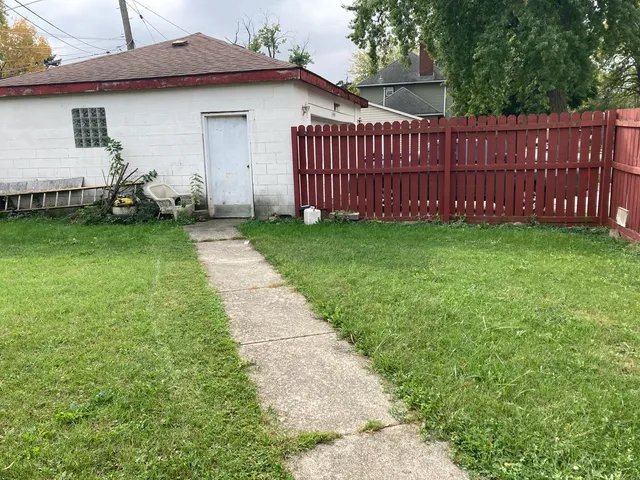a view of a house with backyard and wooden fence