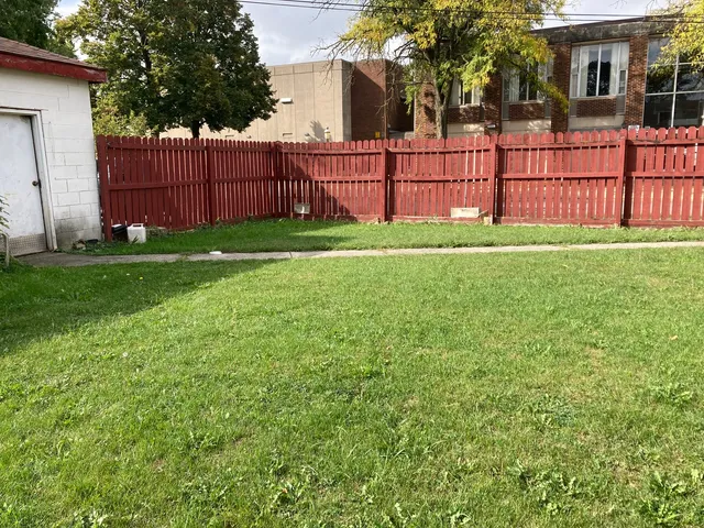 a view of a backyard with a garden and wooden fence