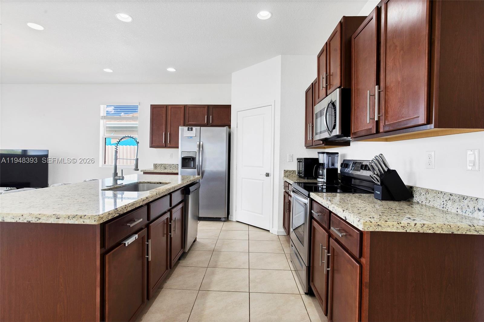 27440 Southwest 135th Ave Road Homestead, FL 33032 - Photo 30 of 75 a kitchen with stainless steel appliances granite countertop a sink a stove and a refrigerator