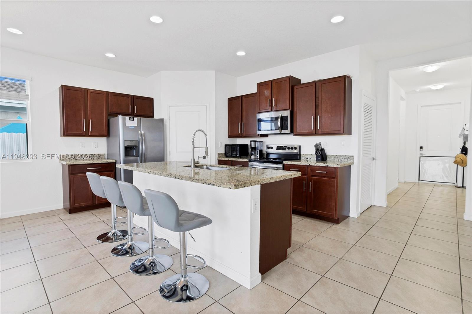 27440 Southwest 135th Ave Road Homestead, FL 33032 - Photo 33 of 75 a kitchen with stainless steel appliances granite countertop a stove a sink a microwave a refrigerator and cabinets