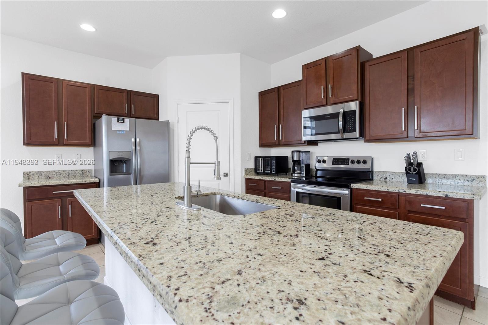 27440 Southwest 135th Ave Road Homestead, FL 33032 - Photo 34 of 75 a kitchen with stainless steel appliances granite countertop a stove refrigerator sink and microwave