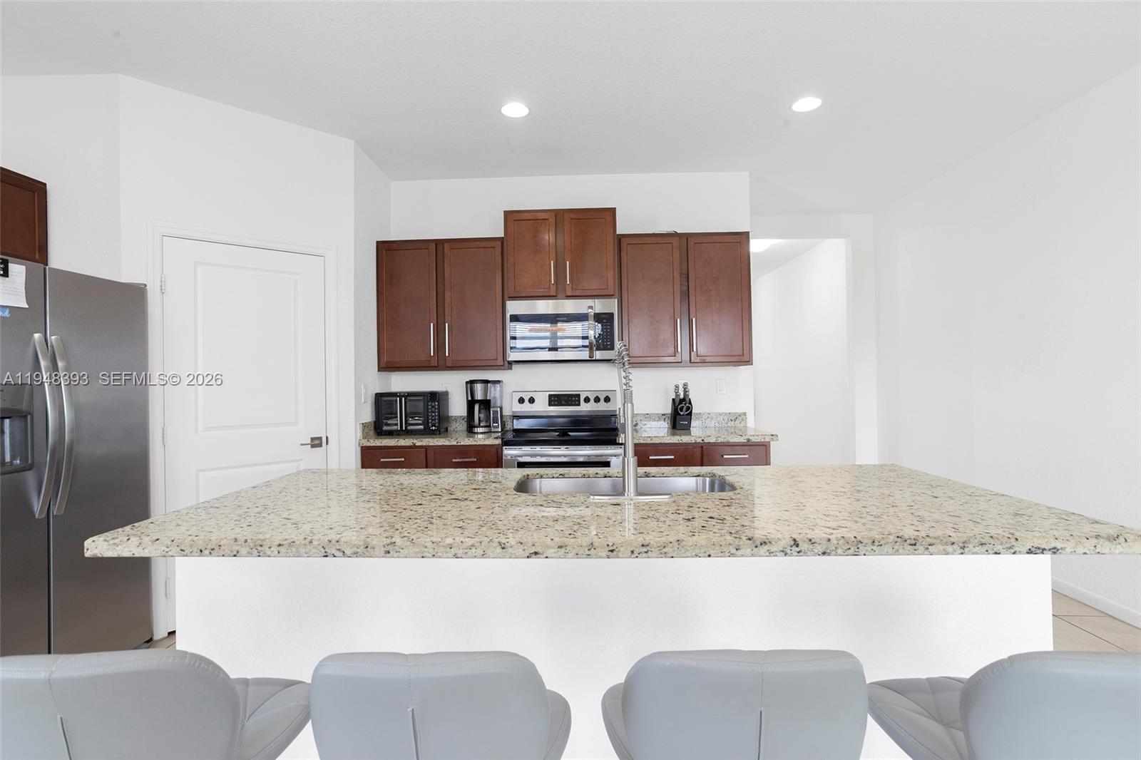 27440 Southwest 135th Ave Road Homestead, FL 33032 - Photo 36 of 75 a kitchen with stainless steel appliances granite countertop a stove top oven a refrigerator a sink and a granite counter tops