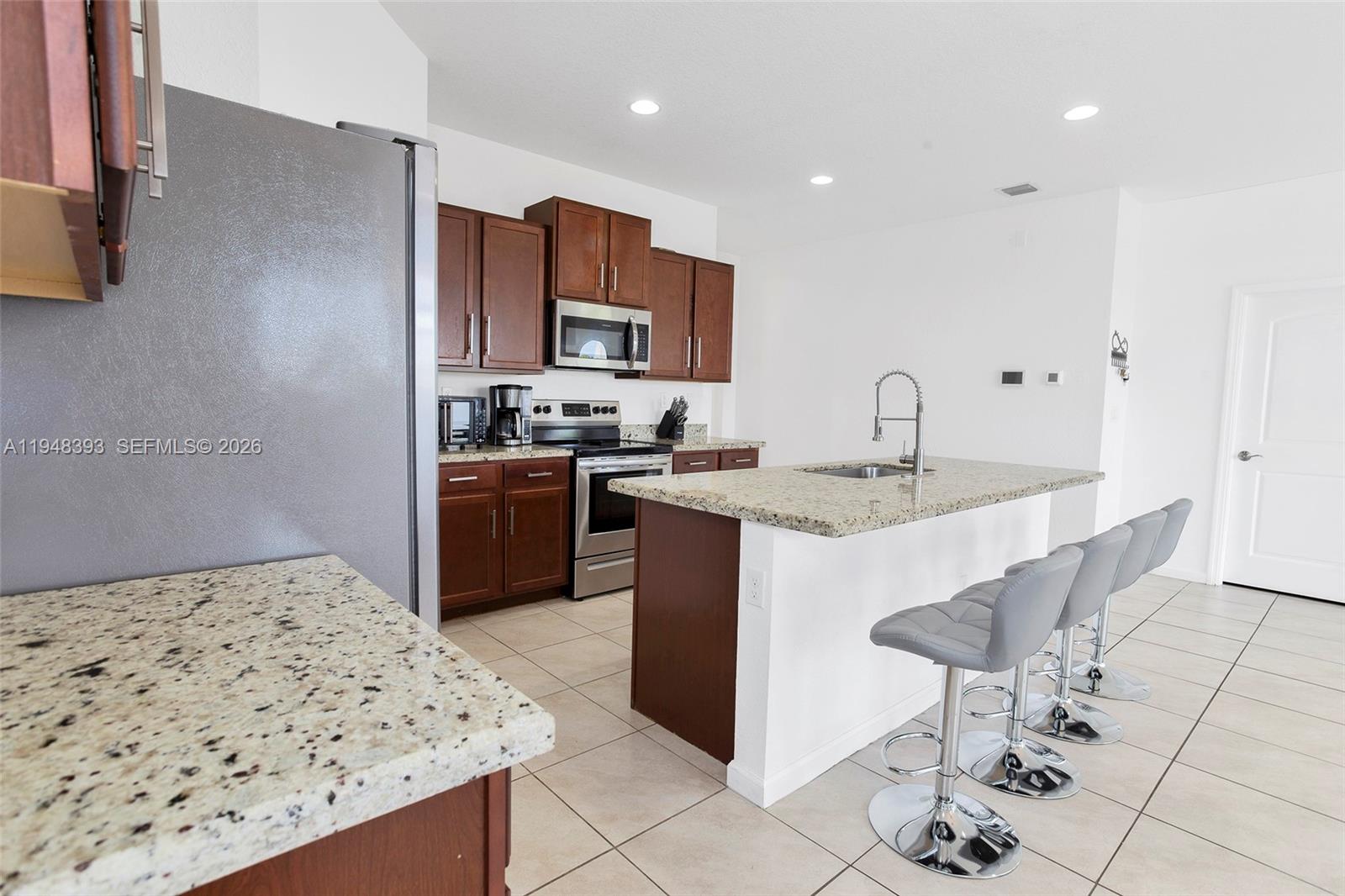 27440 Southwest 135th Ave Road Homestead, FL 33032 - Photo 37 of 75 a kitchen with stainless steel appliances granite countertop a sink stove and refrigerator