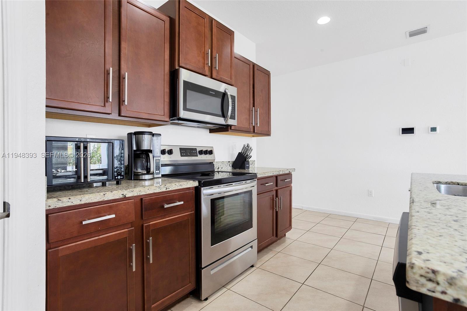 27440 Southwest 135th Ave Road Homestead, FL 33032 - Photo 39 of 75 a kitchen with stainless steel appliances granite countertop a stove and a microwave