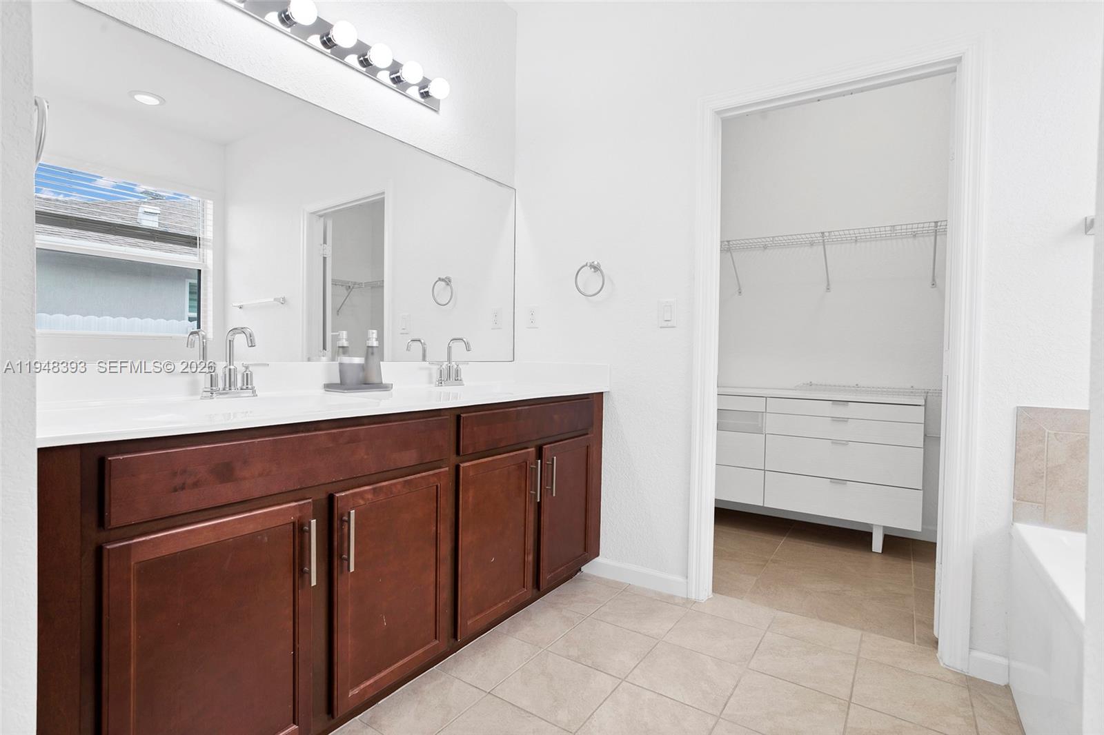 27440 Southwest 135th Ave Road Homestead, FL 33032 - Photo 50 of 75 a bathroom with a double vanity sink a mirror and a bathtub