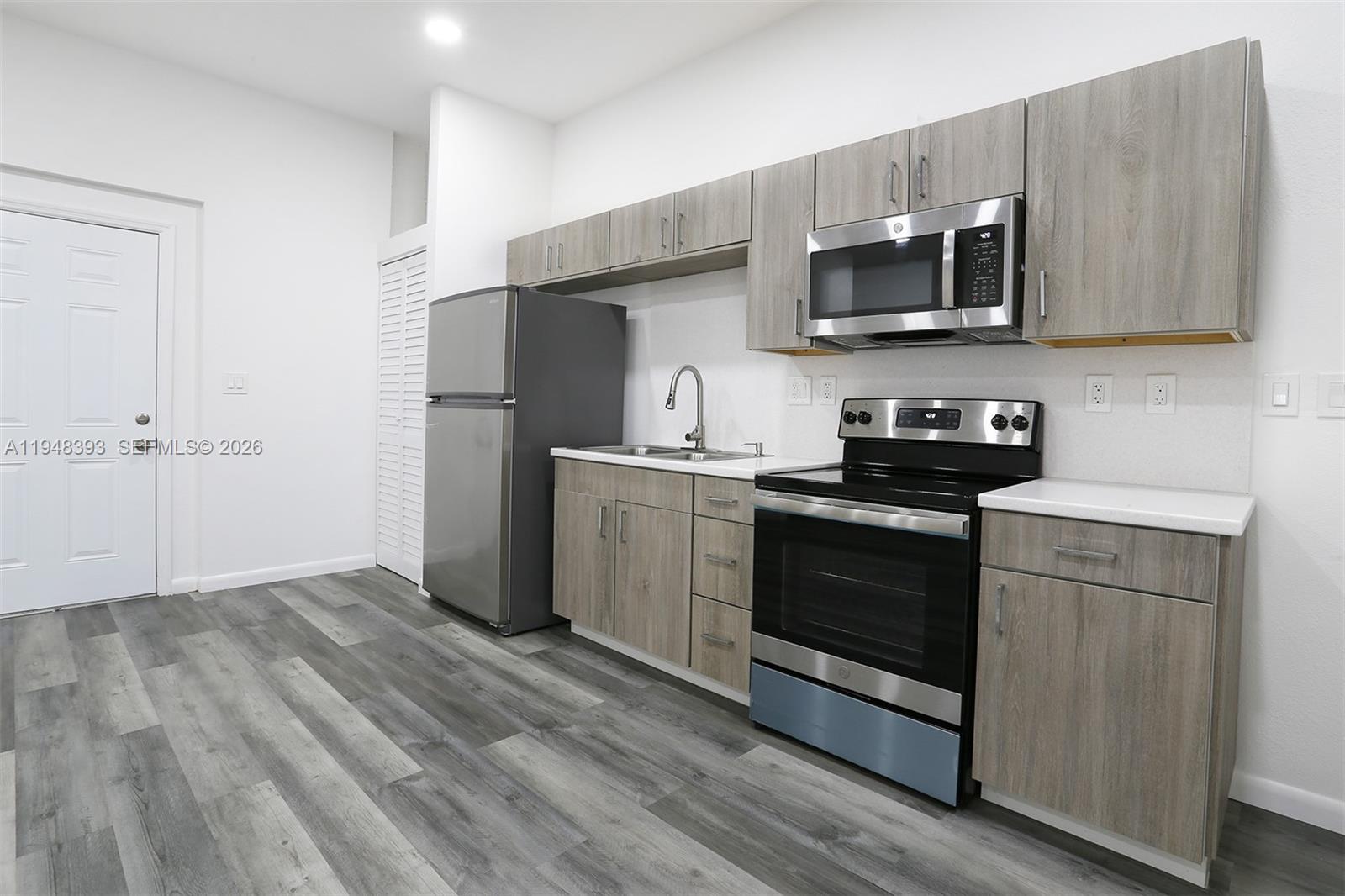 27440 Southwest 135th Ave Road Homestead, FL 33032 - Photo 75 of 75 a kitchen with stainless steel appliances granite countertop a refrigerator stove a sink and dishwasher with wooden floor