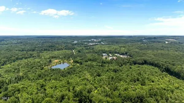 an aerial view of residential houses with outdoor space and trees all around