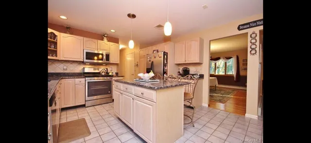 a kitchen with stainless steel appliances kitchen island granite countertop a sink and cabinets