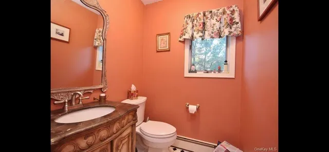 a bathroom with a granite countertop toilet sink and mirror