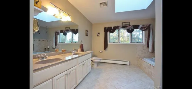 a bathroom with a granite countertop sink mirror and a bathtub