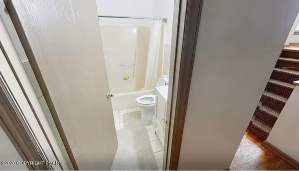a white toilet sitting next to a shower curtain