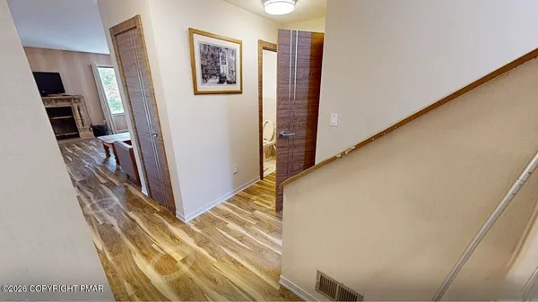 a view of a hallway with wooden floor and entryway