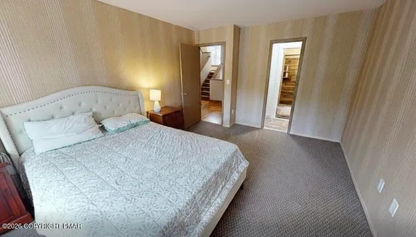 a bedroom with a bed and closet with wooden floor