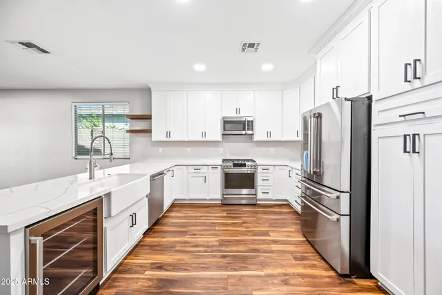 a kitchen with stainless steel appliances a refrigerator sink and microwave