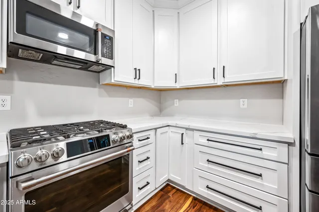 a kitchen with white cabinets and appliances