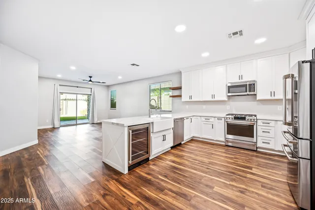 a large kitchen with cabinets wooden floor and stainless steel appliances