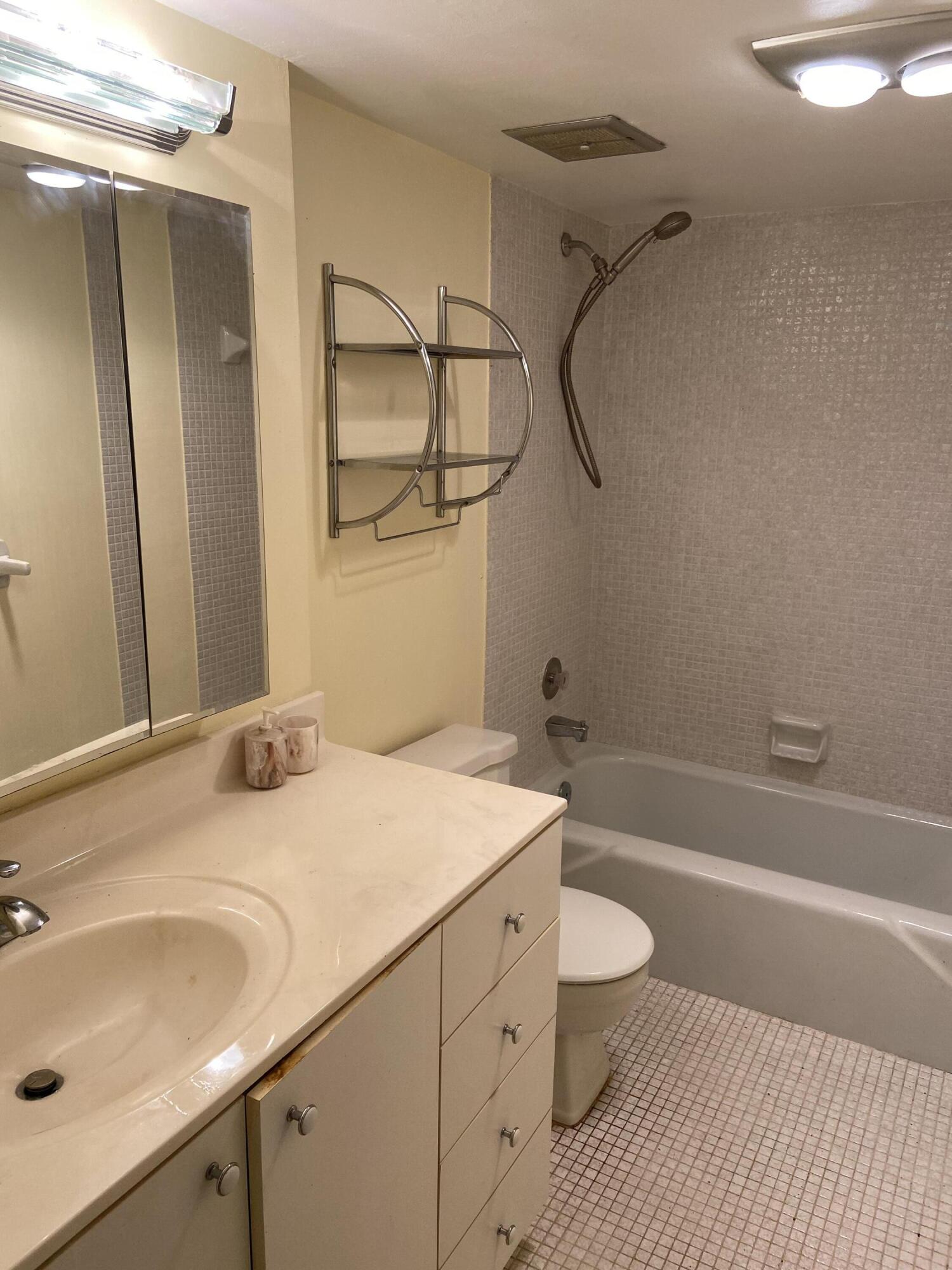 3090 Holiday Springs Boulevard, Unit 310 Margate, FL 33063 - Photo 11 of 26 a bathroom with a sink toilet vanity and shower
