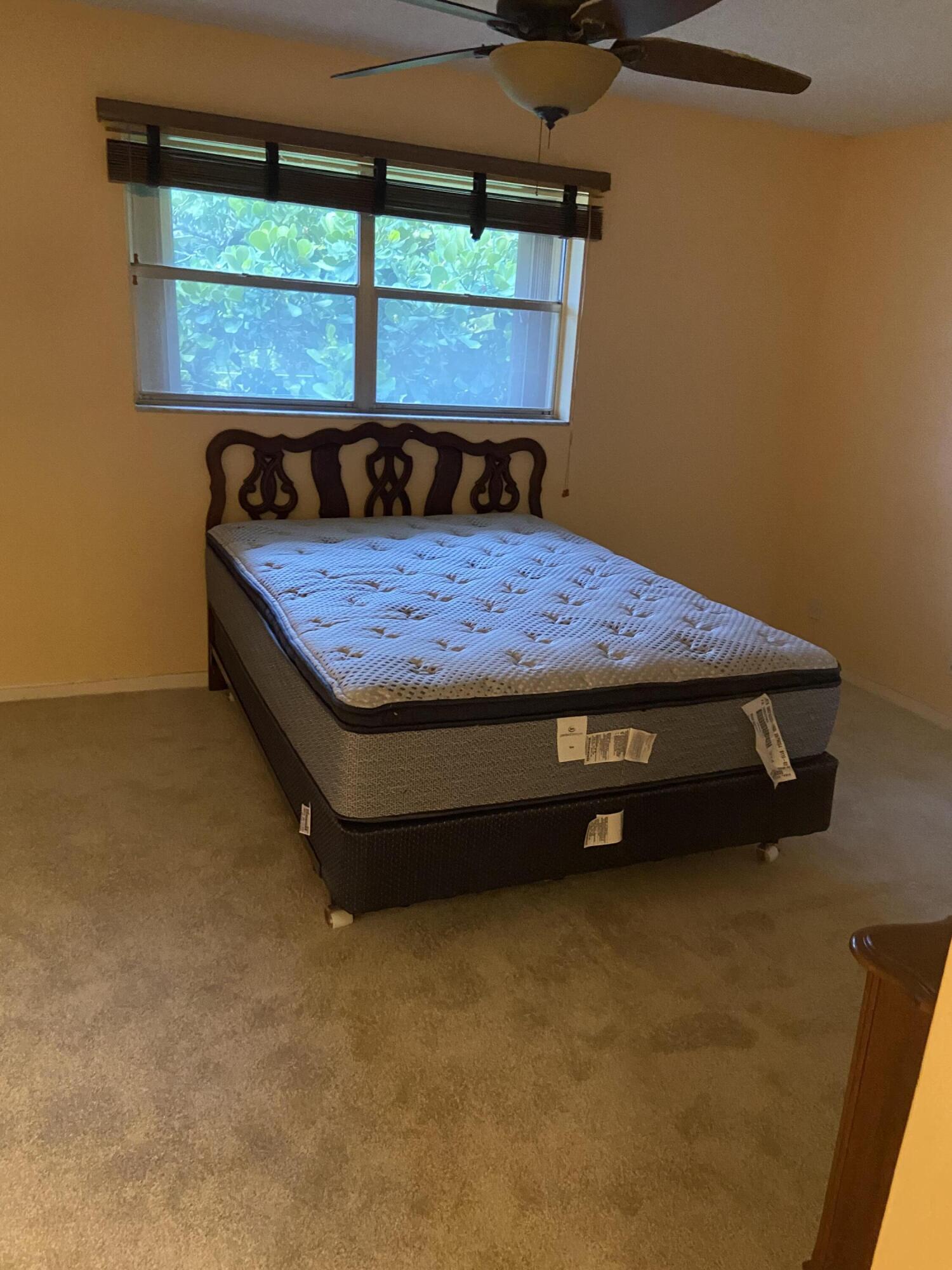 3090 Holiday Springs Boulevard, Unit 310 Margate, FL 33063 - Photo 18 of 26 a bed sitting in a room next to a window