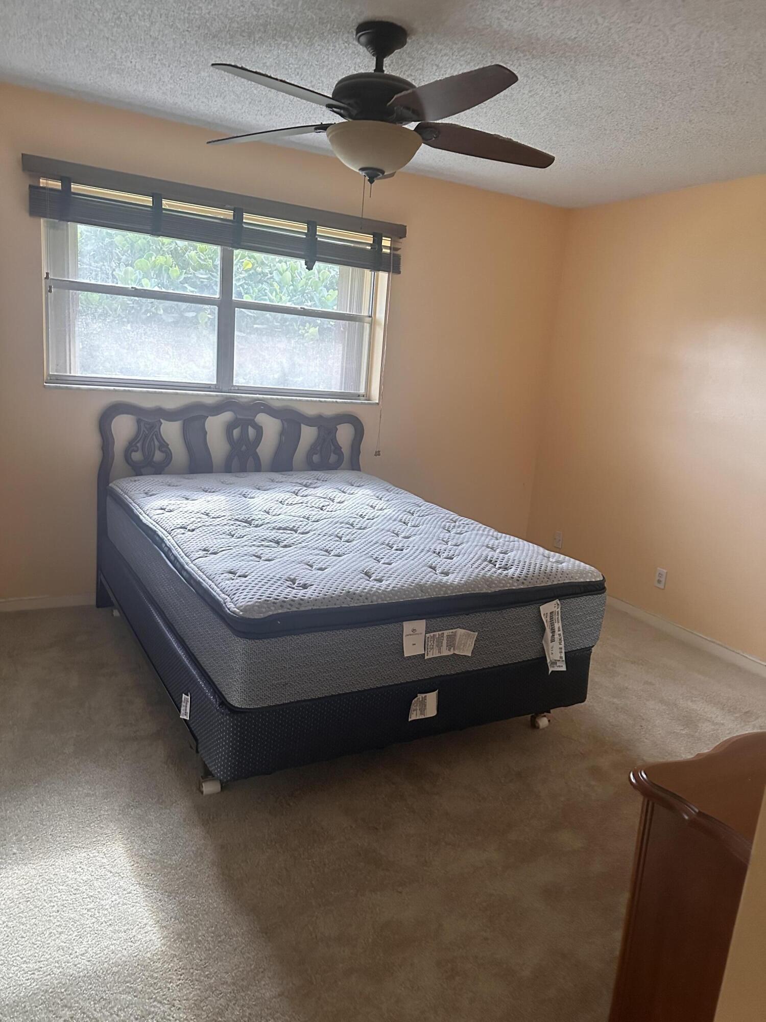 3090 Holiday Springs Boulevard, Unit 310 Margate, FL 33063 - Photo 19 of 26 a bed sitting in a bedroom next to a window