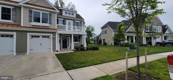 a front view of a house with a garden and trees