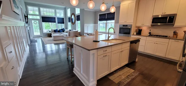 a kitchen with stainless steel appliances granite countertop a sink a stove and a refrigerator