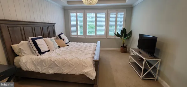 a bedroom with a bed and a flat tv screen on a dresser