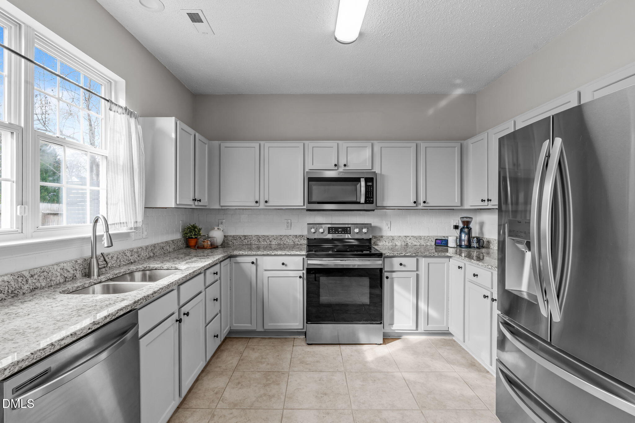 400 New Timber Path Apex, NC 27502 - Photo 9 of 34 a kitchen with stainless steel appliances granite countertop a stove top oven a sink and a refrigerator