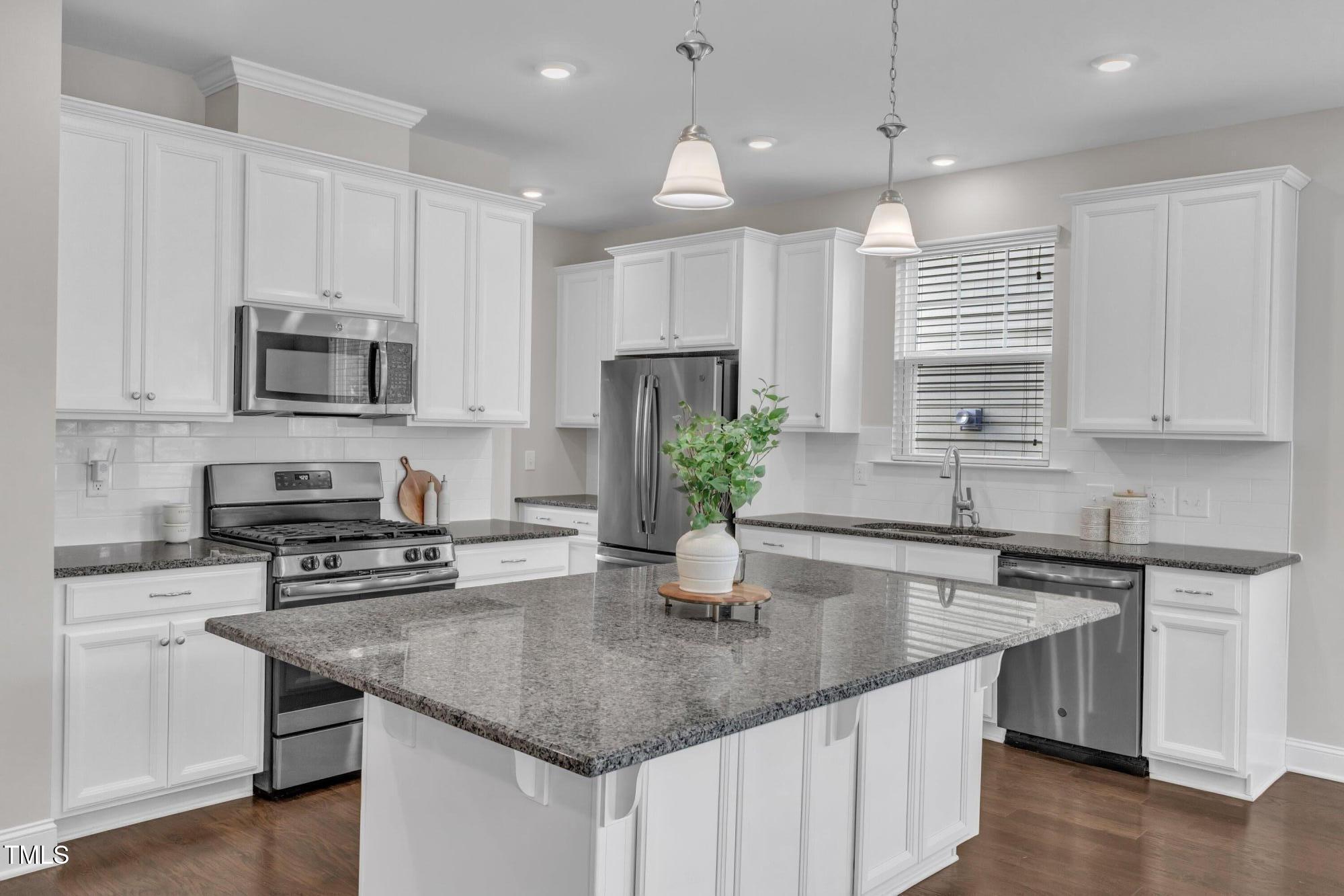 a kitchen with stainless steel appliances granite countertop a sink a stove and cabinets