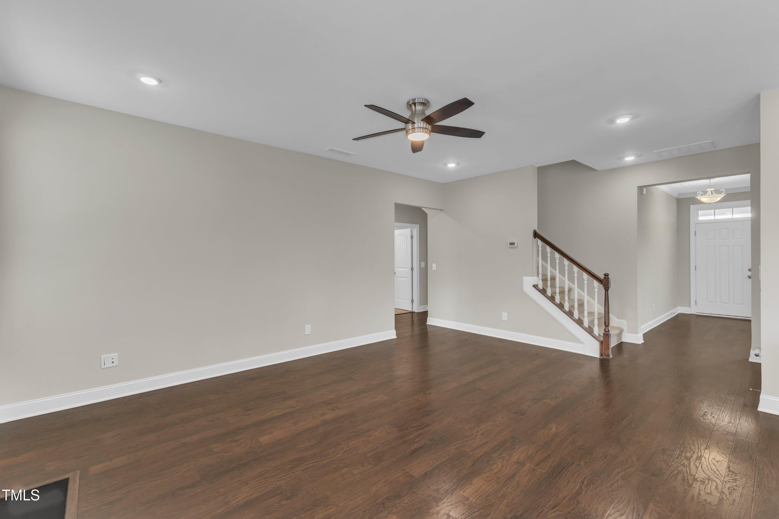 4252 Rockdell Hall Street Raleigh, NC 27616 - Photo 18 of 64 a view of an empty room with wooden floor and a ceiling fan