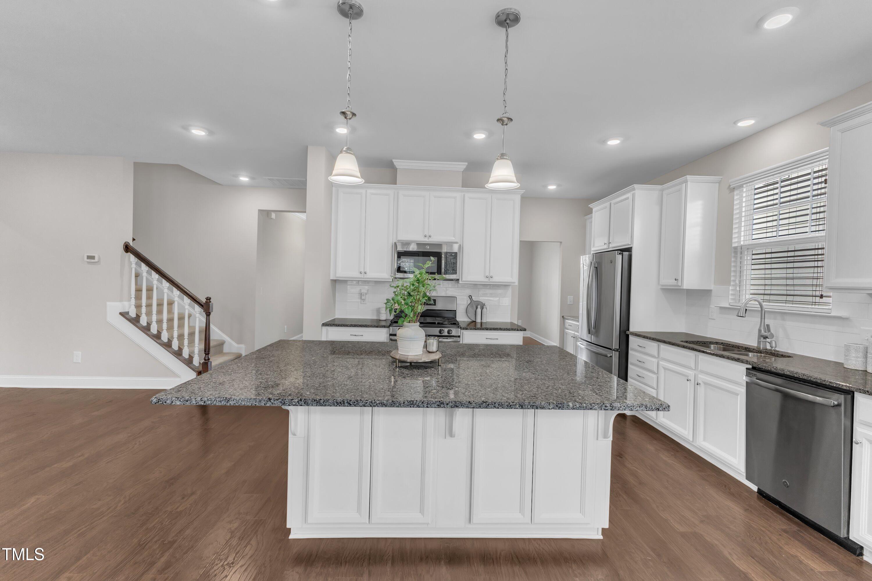 4252 Rockdell Hall Street Raleigh, NC 27616 - Photo 21 of 64 a kitchen with stainless steel appliances granite countertop a sink a refrigerator and a granite counter tops