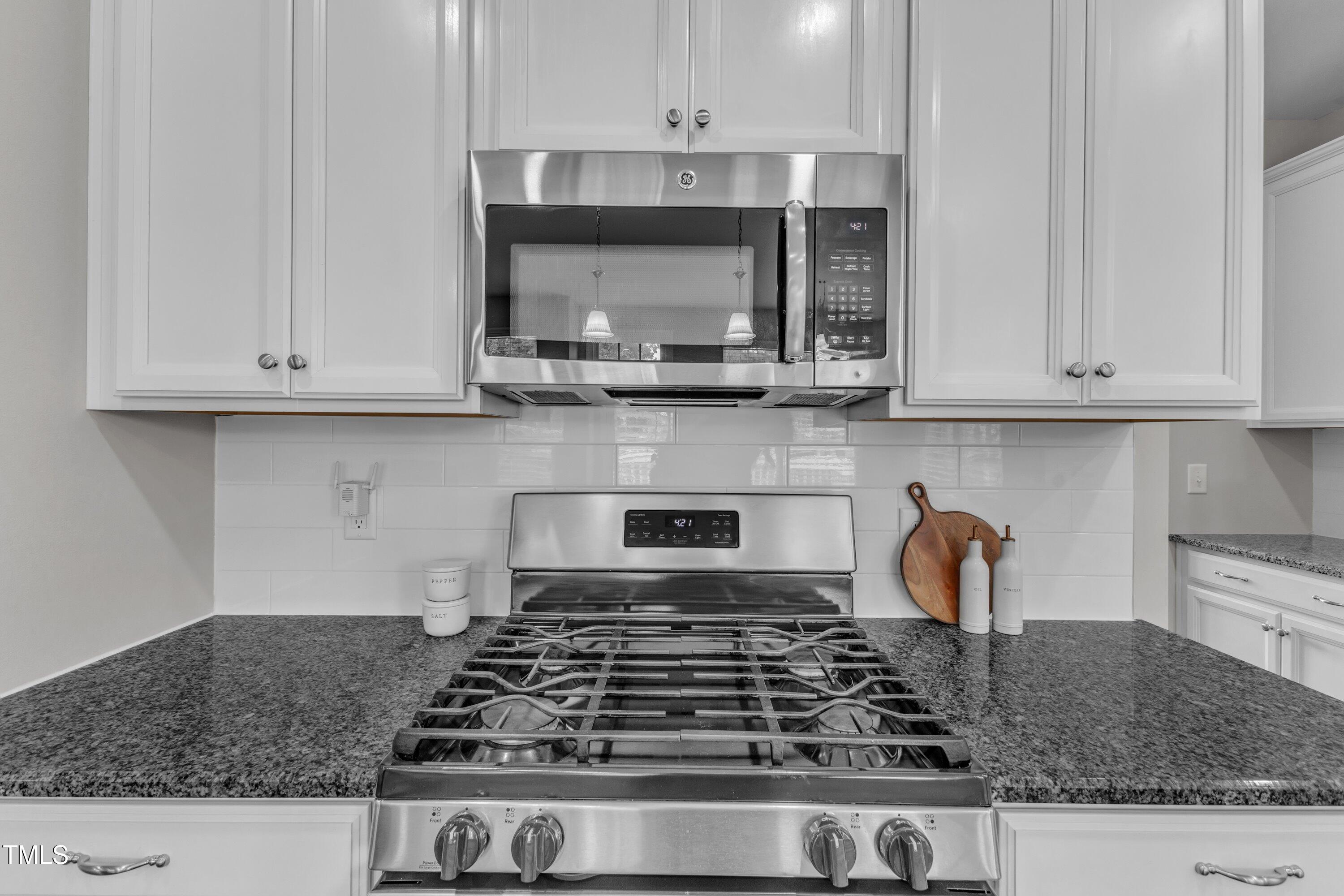 4252 Rockdell Hall Street Raleigh, NC 27616 - Photo 23 of 64 a kitchen with granite countertop white cabinets and a stove