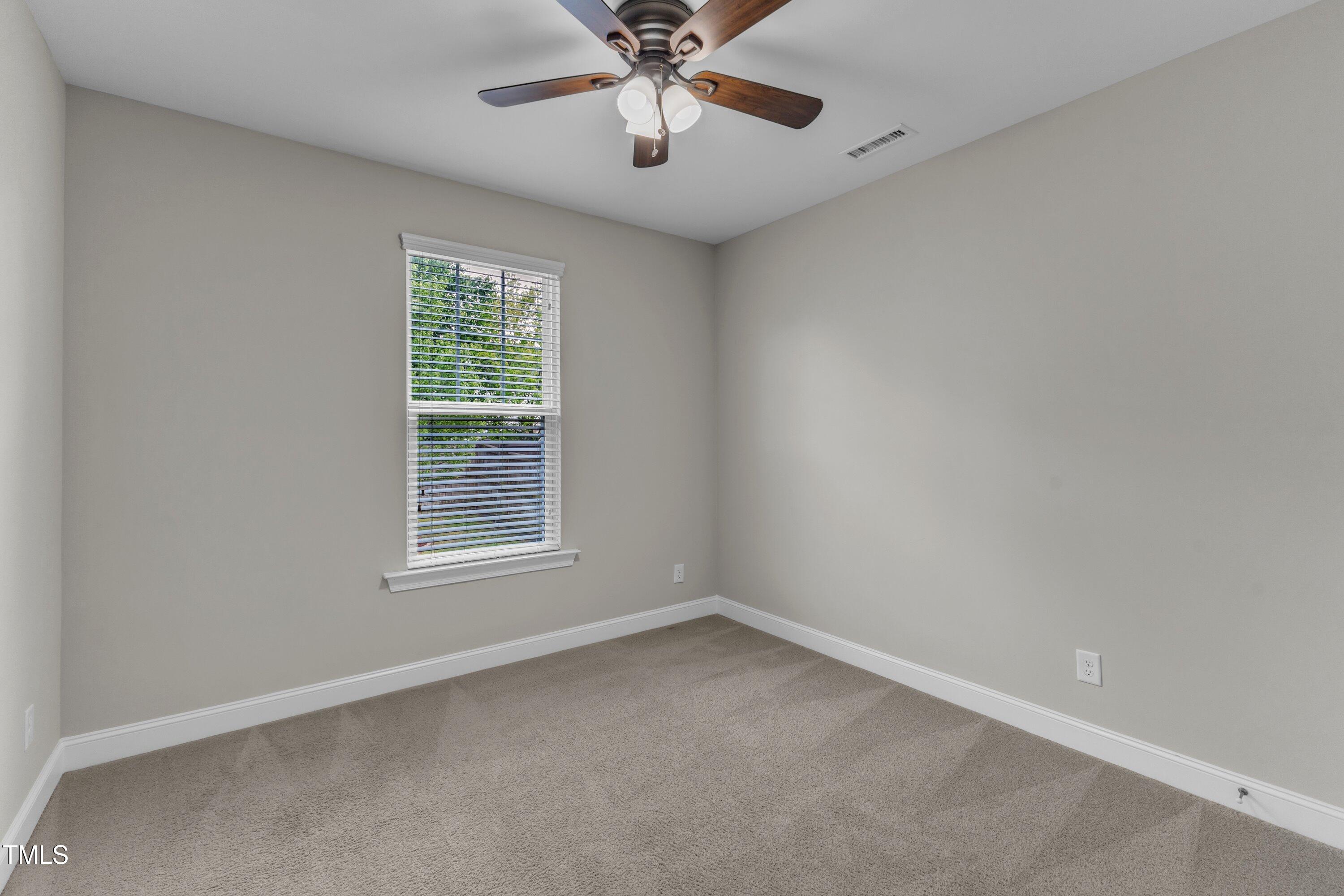 4252 Rockdell Hall Street Raleigh, NC 27616 - Photo 27 of 64 an empty room with a window and a fan