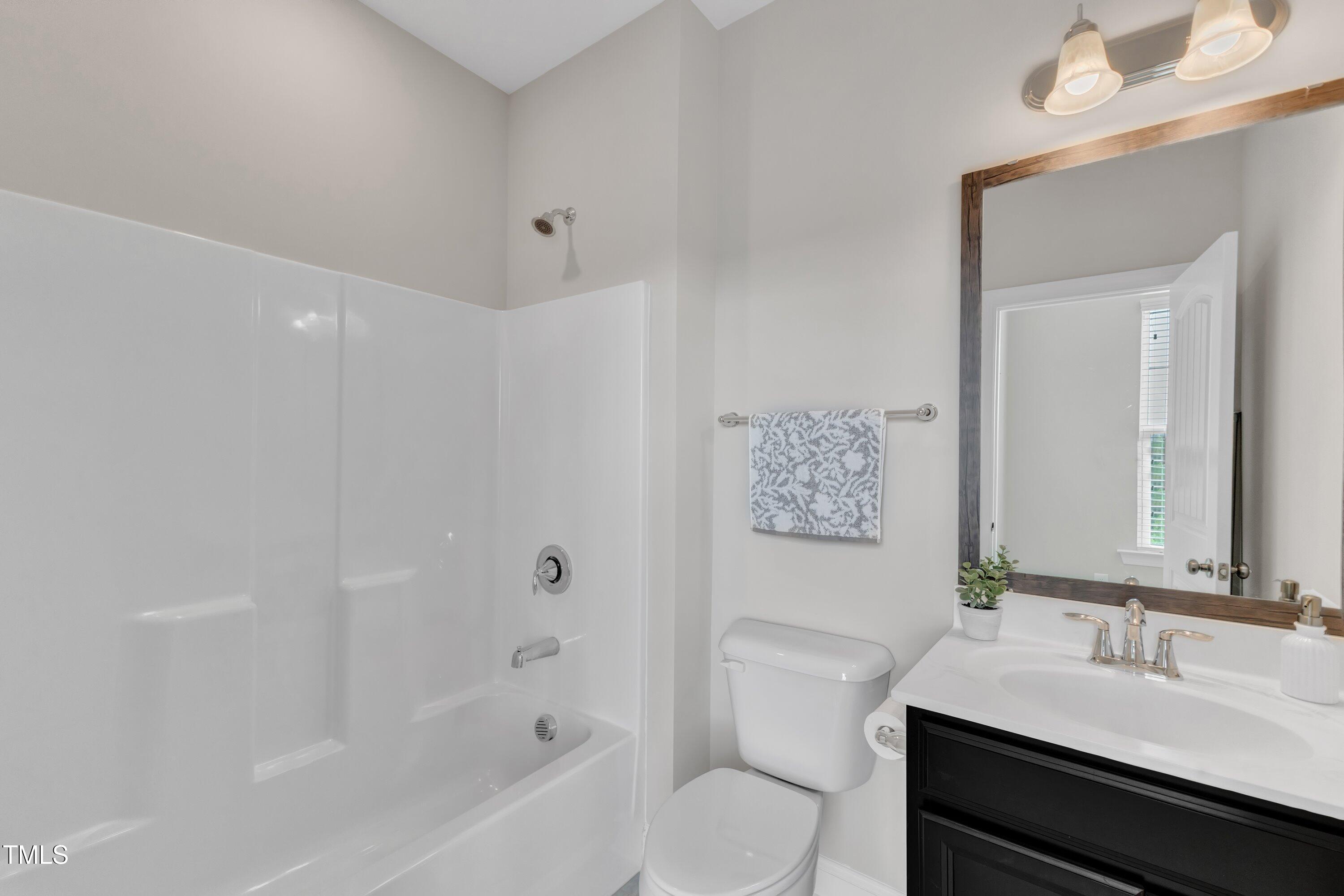 4252 Rockdell Hall Street Raleigh, NC 27616 - Photo 40 of 64 a bathroom with a sink a toilet and shower