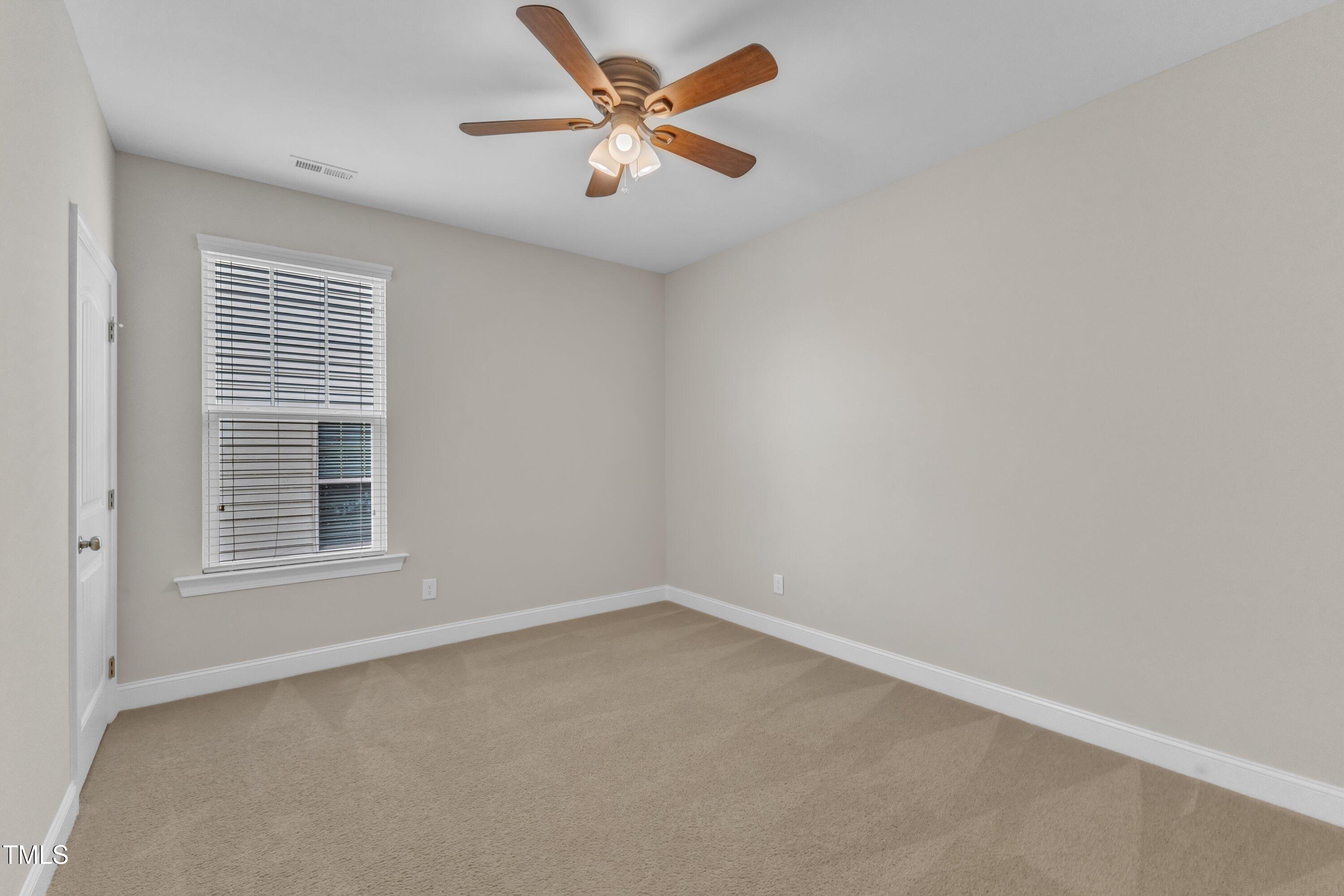 4252 Rockdell Hall Street Raleigh, NC 27616 - Photo 45 of 64 an empty room with a window and a fan