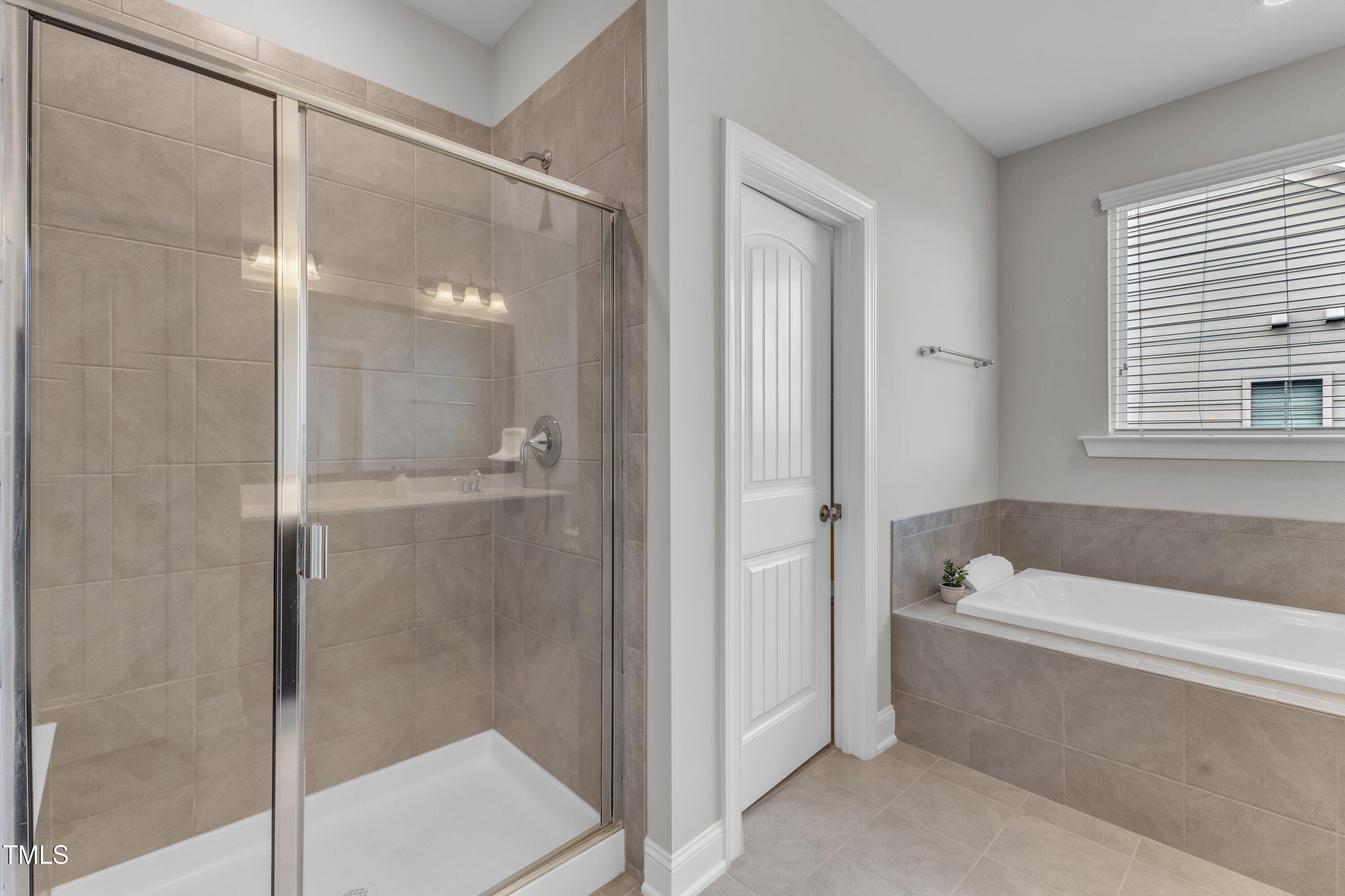 4252 Rockdell Hall Street Raleigh, NC 27616 - Photo 51 of 64 a bathroom with a tub shower and a sink
